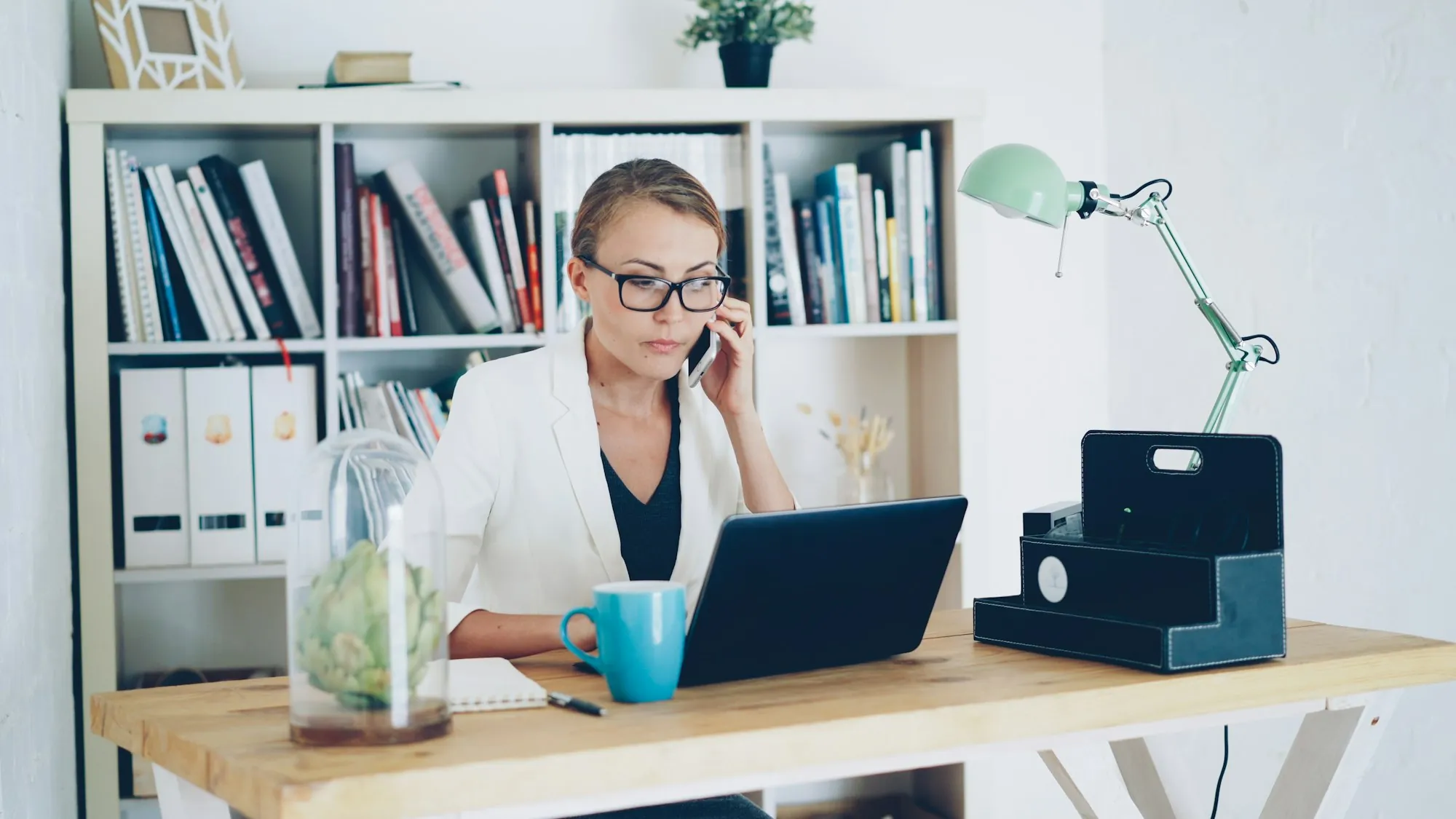 A woman on the telephone at a desk with papers