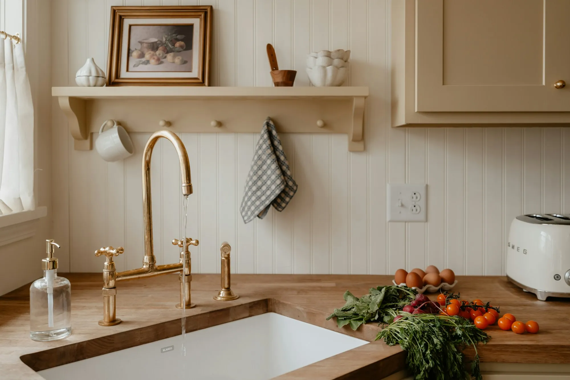 A kitchen with a clean sink, shelf and worktop