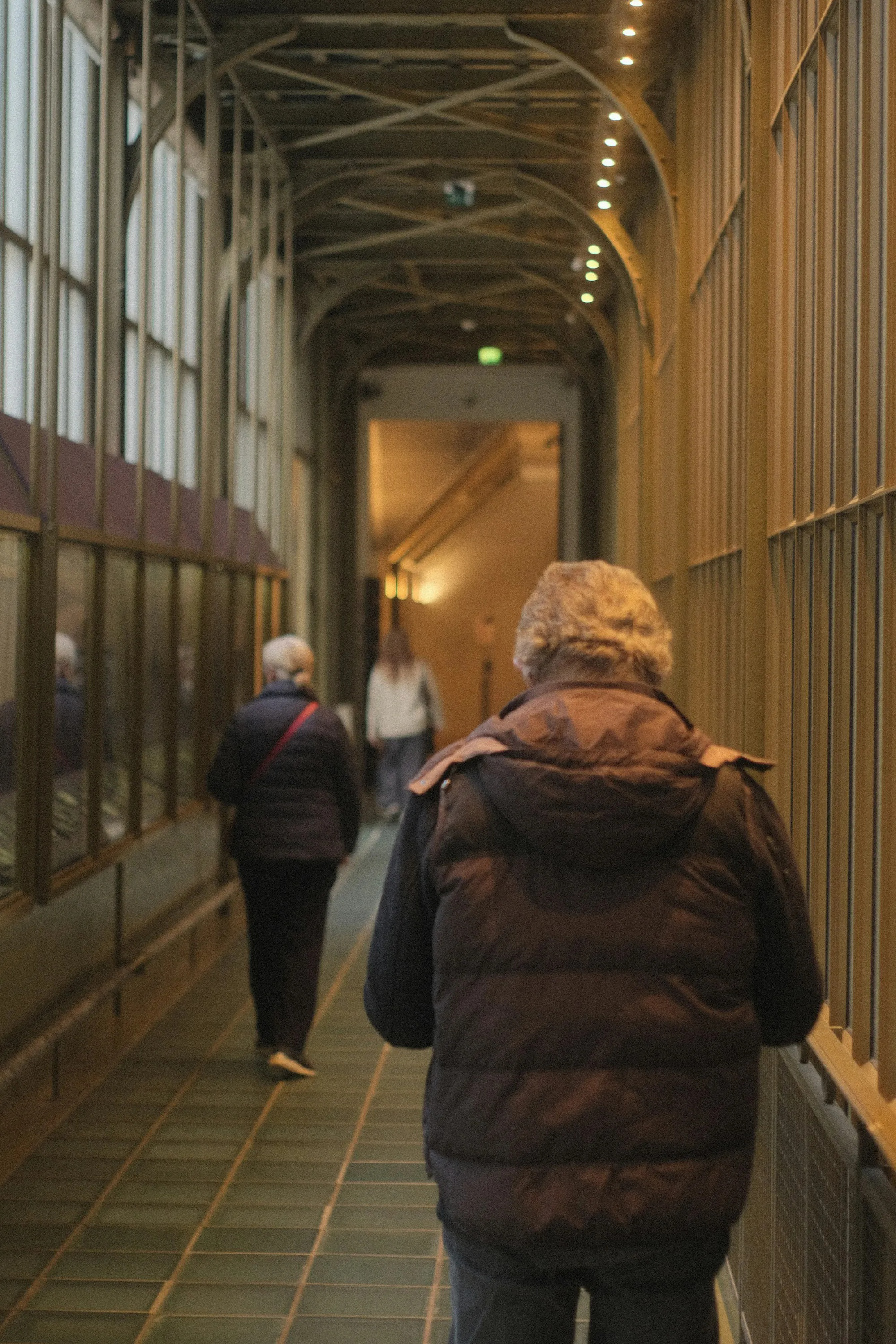 Two people walking together along an indoor corridor
